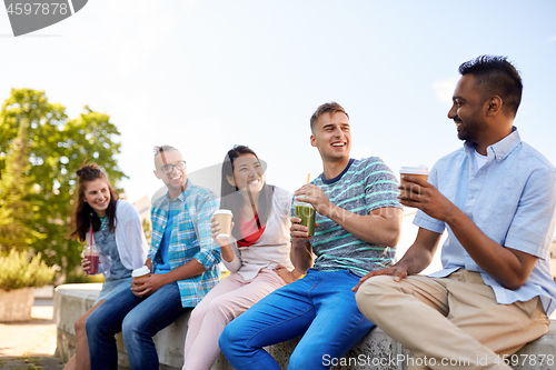 Image of friends drinking coffee and juice talking in city