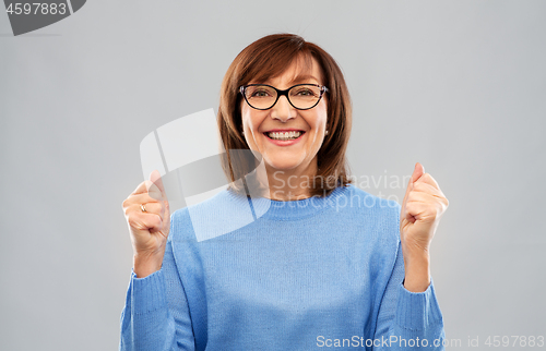 Image of portrait of happy senior woman celebrating triumph