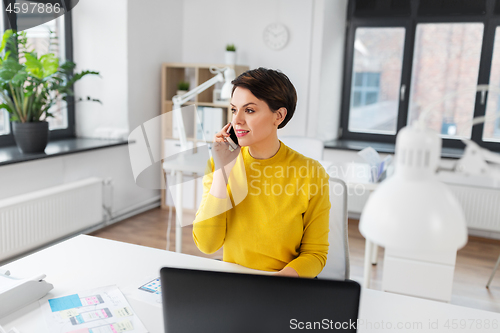 Image of happy ui designer calling on smartphone at office