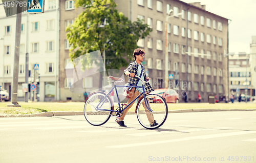 Image of young man with fixed gear bicycle on crosswalk