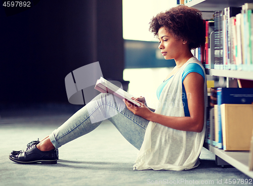 Image of african student girl reading book at library