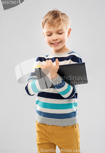 Image of boy in striped pullover with tablet pc computer