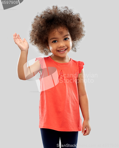 Image of happy little african american girl waving hand