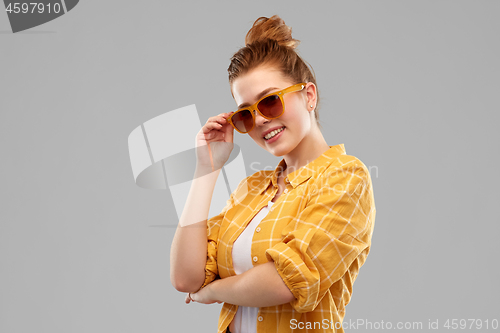 Image of smiling red haired teenage girl in sunglasses