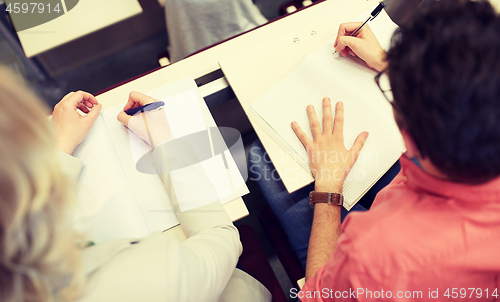 Image of students writing to notebooks at exam or lecture