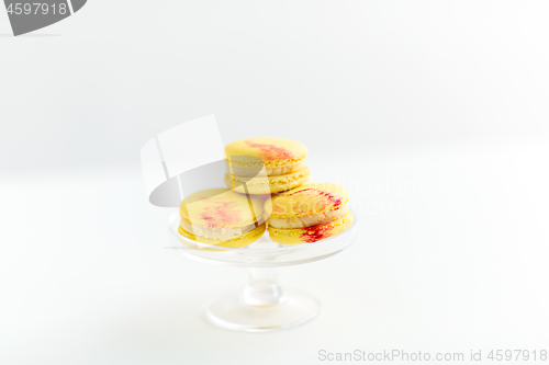 Image of lemon yellow macarons on glass confectionery stand