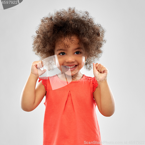 Image of happy little african american girl over grey