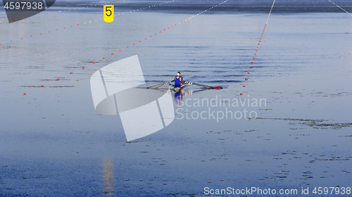 Image of Two man in a sports boat rowing on the lake