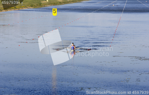 Image of Two man in a sports boat rowing on the lake