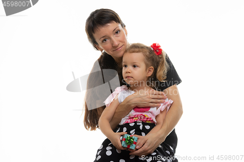 Image of Four-year-old daughter sits on mother\'s lap, white background