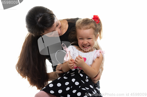 Image of Mom tickles her four-year-old daughter