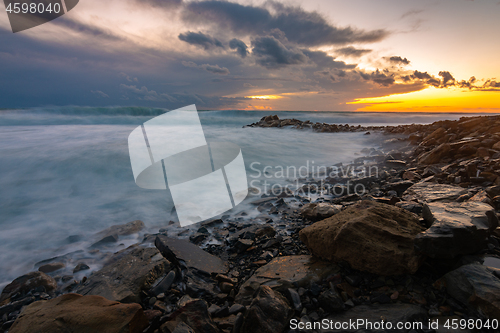 Image of Waves roll on rocky shore during storm