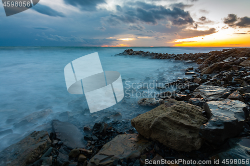 Image of Seascape at sunset, waves roll ashore