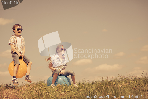 Image of Brother and sister playing on the field