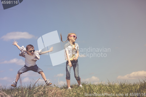 Image of Brother and sister playing on the field