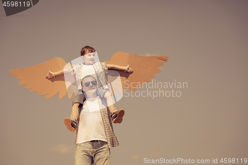 Image of Father and son playing with cardboard toy wings