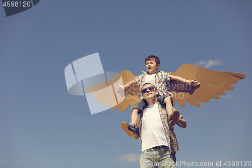 Image of Father and son playing with cardboard toy wings