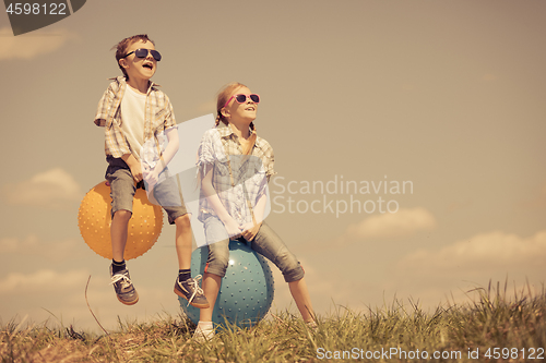 Image of Brother and sister playing on the field