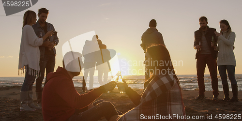 Image of Friends having fun at beach on autumn day