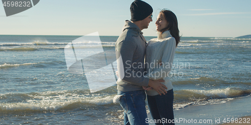 Image of Couple having fun on beautiful autumn day at beach