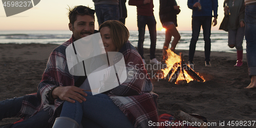 Image of Friends having fun at beach on autumn day