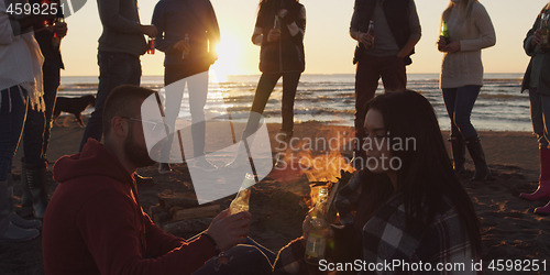 Image of Friends having fun at beach on autumn day