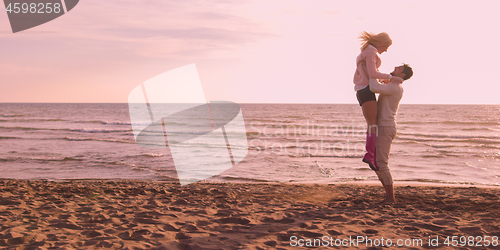 Image of Loving young couple on a beach at autumn on sunny day