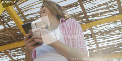 Image of Smartphone Woman Texting On Cell Phone At Beach