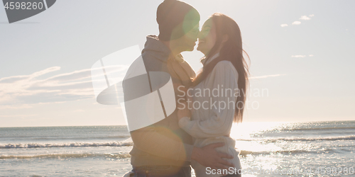 Image of Couple having fun on beautiful autumn day at beach