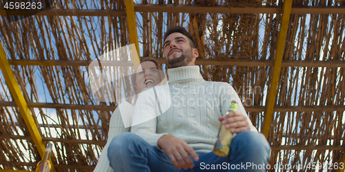 Image of Couple drinking beer together at the beach