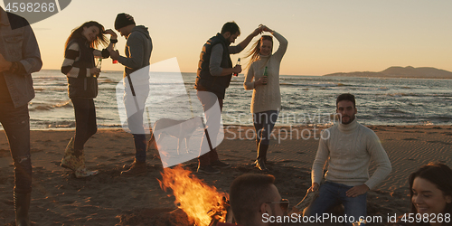 Image of Friends having fun at beach on autumn day