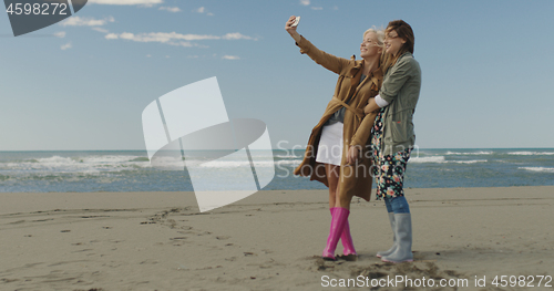 Image of Girls having time and taking selfie on a beach