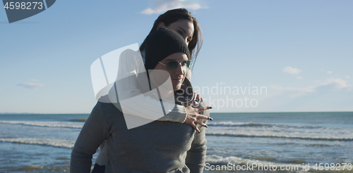 Image of couple having fun at beach during autumn