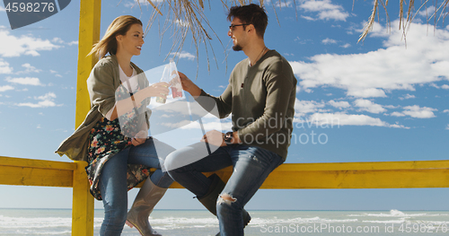 Image of Group of friends having fun on autumn day at beach