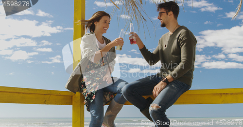 Image of Group of friends having fun on autumn day at beach