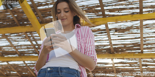 Image of Smartphone Woman Texting On Cell Phone At Beach