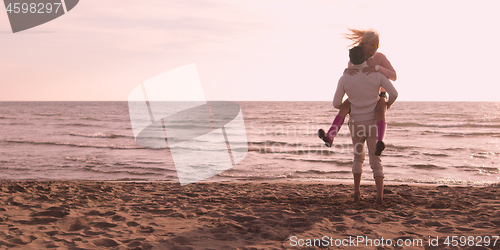 Image of Loving young couple on a beach at autumn on sunny day