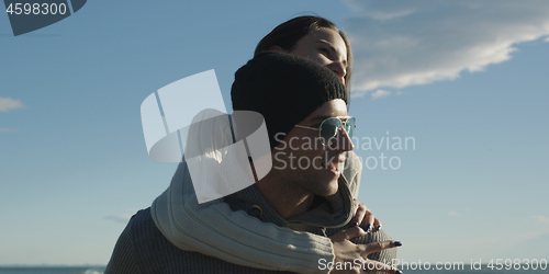 Image of couple having fun at beach during autumn