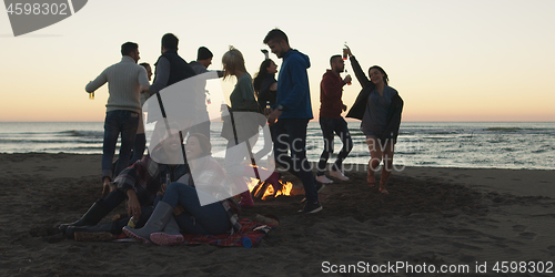 Image of Friends having fun at beach on autumn day