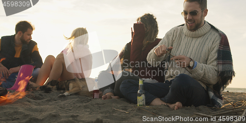 Image of Friends Relaxing At Bonfire Beach Party