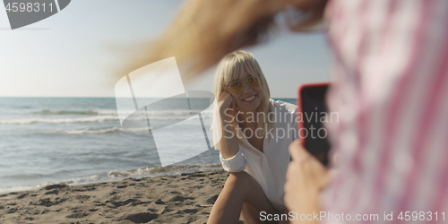 Image of Two girl friends having fun photographing each other on vecation