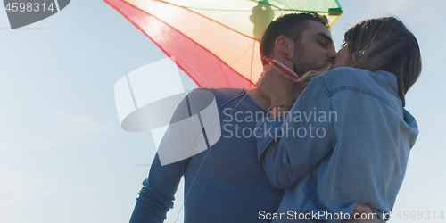 Image of Happy couple having fun with kite on beach