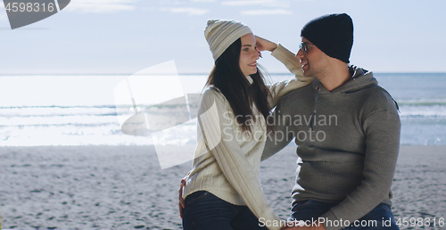 Image of Couple having fun on beautiful autumn day at beach