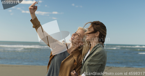 Image of Girls having time and taking selfie on a beach