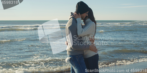 Image of Couple having fun on beautiful autumn day at beach