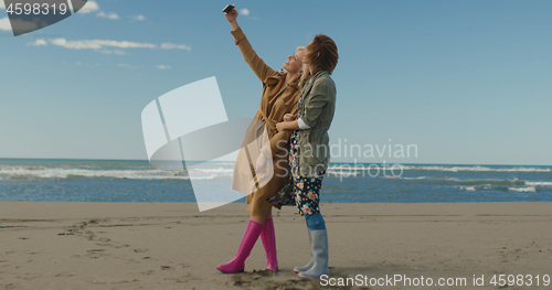 Image of Girls having time and taking selfie on a beach