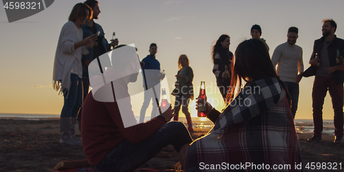 Image of Friends having fun at beach on autumn day