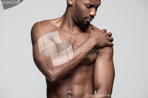 Image of Young man overwhelmed with a pain in the shoulder