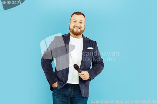 Image of Young man with microphone on blue background, leading concept