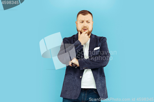 Image of Young man with microphone on blue background, leading concept